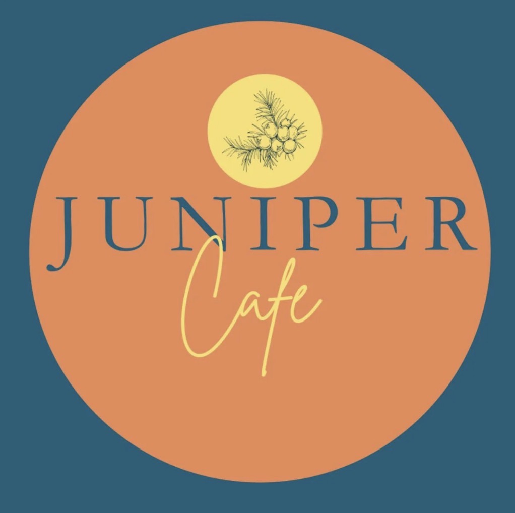 The Juniper Cafe team in front of the moss logo wall